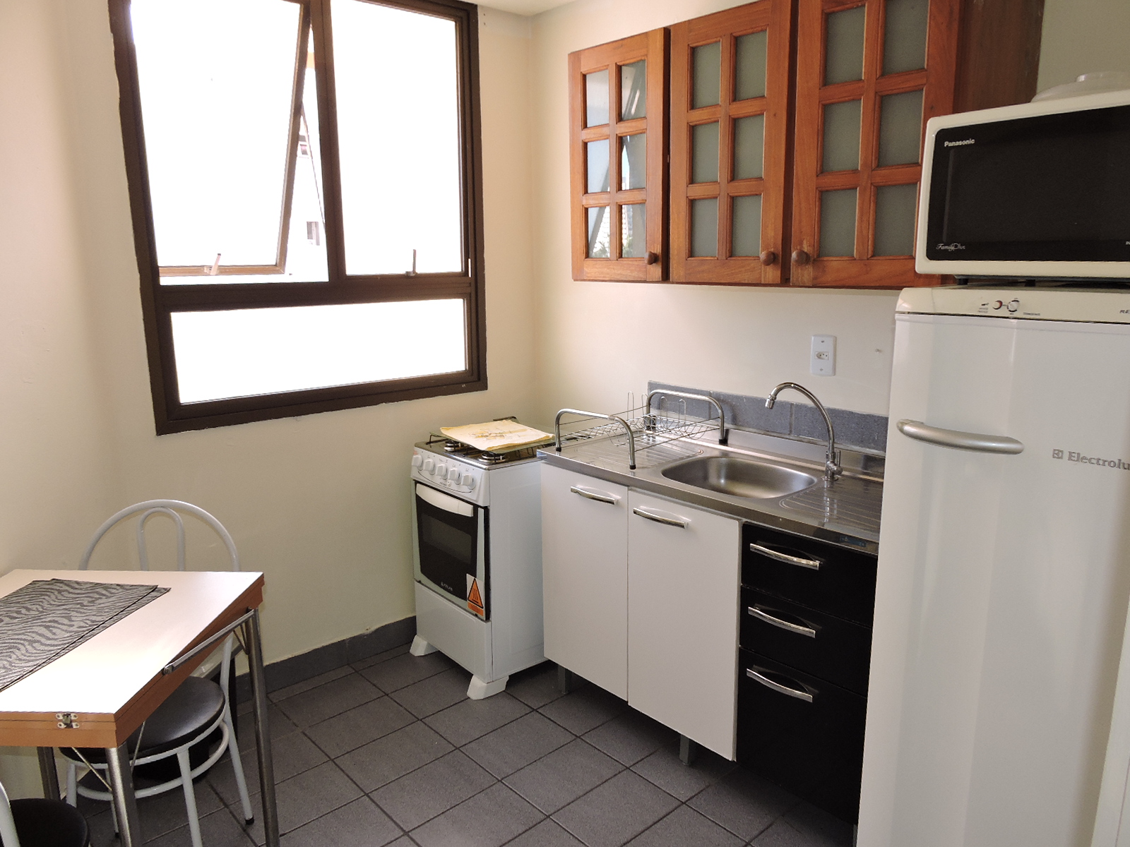 Cozinha equipada com fogão, geladeira e micro-ondas